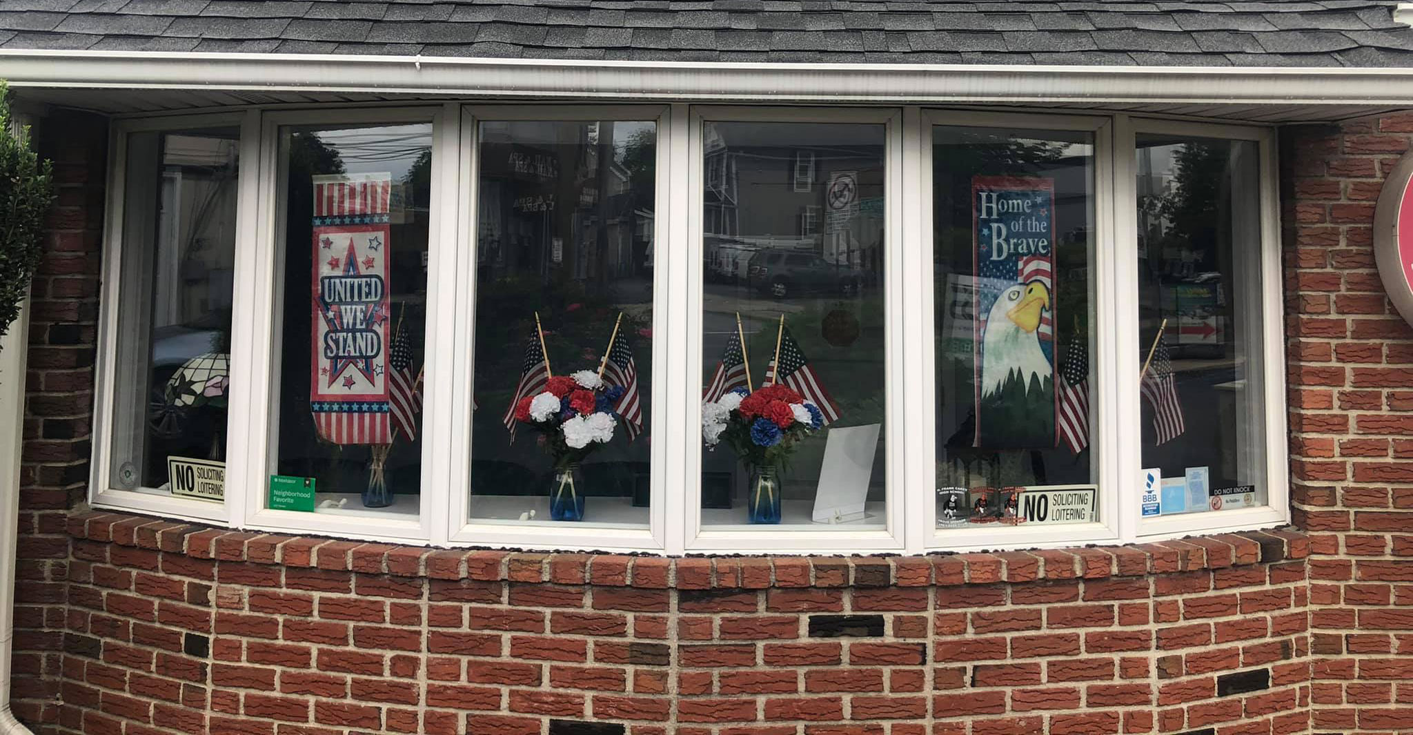 The image shows a storefront with a large window displaying various items, including decorative flags and possibly other merchandise.